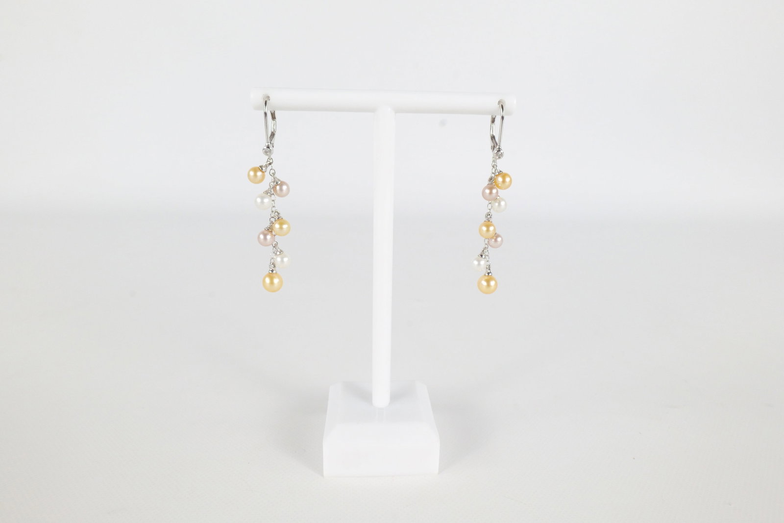 14K Pearl Earrings: 14K white Gold and cultured Pearl dropped earrings. Has seven multi colored cultured pearls going down the length of a chain. Is marked on the inside near the earring clasp. Measures approximately 2".
