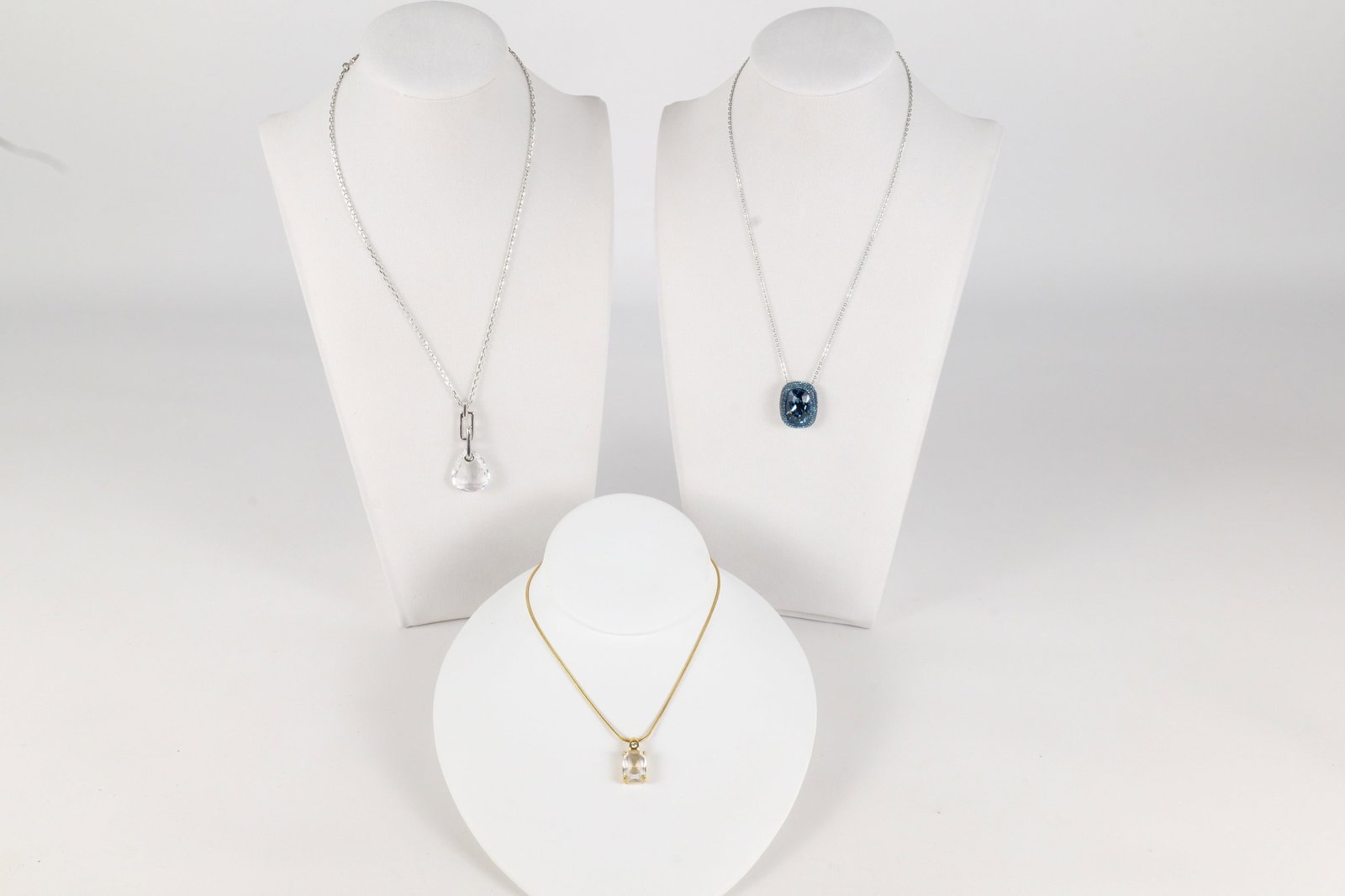 Lot of Swarovski Jewelry: Lot of 3 Swarovski Crystal Necklaces. Including Gold Tone with Two Crystal Pendant measuring 17?, Silver tone with Blue Crystal Pendant with Multiple Rhinestones measuring 17?, and Silver tone Necklac