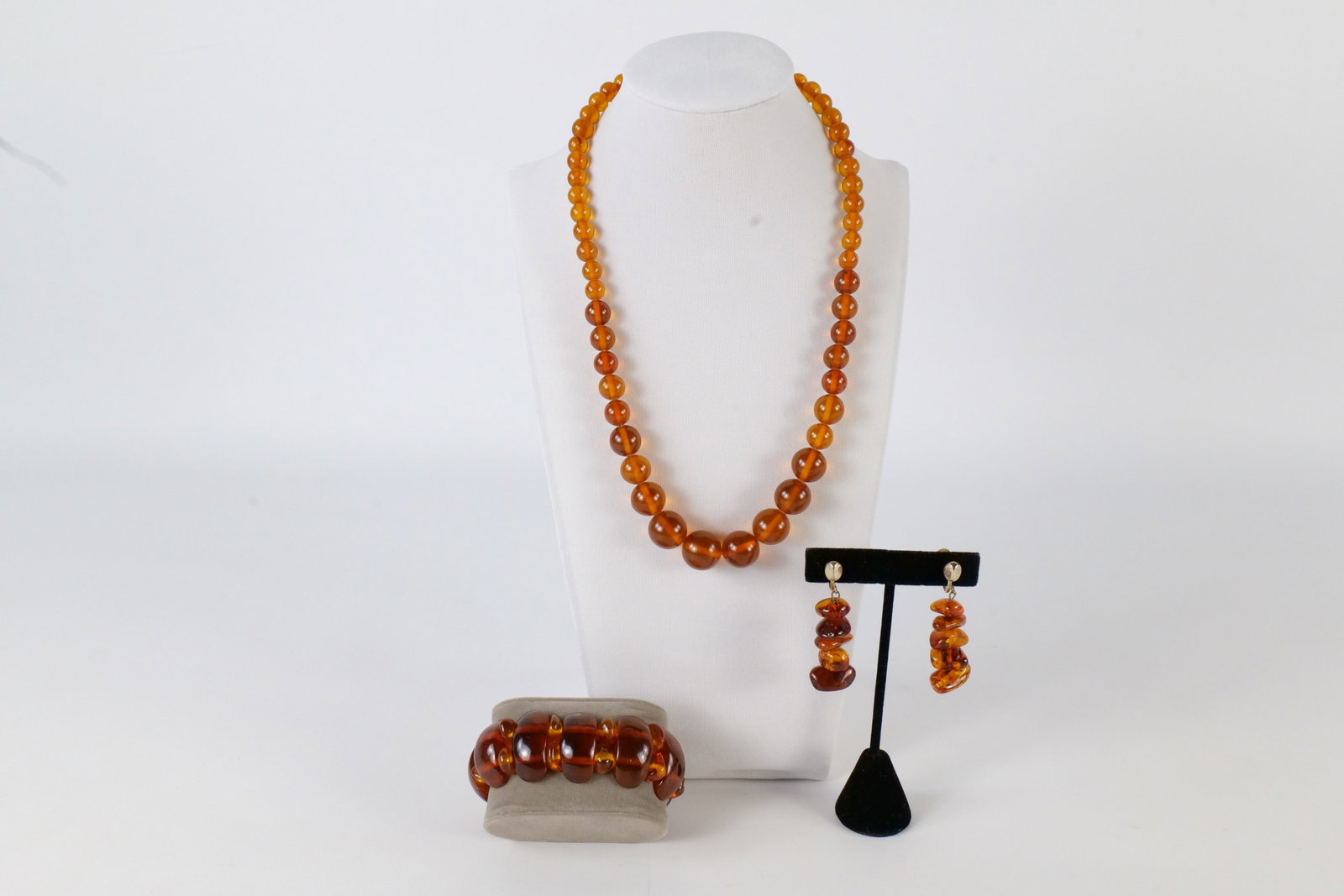 Lot of Amber Jewelry: Lot of Amber Jewelry. Including 20.5" Graduated Bead Necklace, Amber Stretch Beaded Bracelet, and Pair of Amber Drop Screw Back Earrings. The graduated bead necklace has some non amber replacement bea