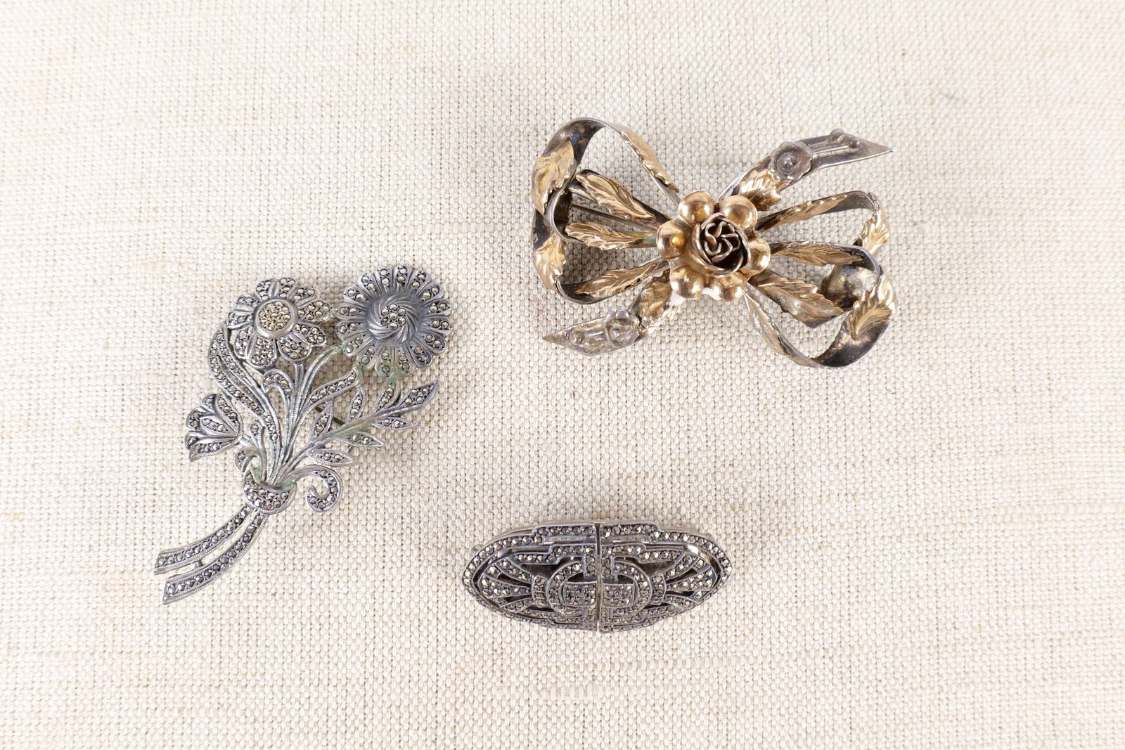 Lot of Sterling Jewelry: Lot of sterling silver jewelry including a flower marcasite pin marked sterling, a marcasite art deco pin or shoe buckle marked CIRO sterling England and a sterling ribbon and floral pin marked HOBE s