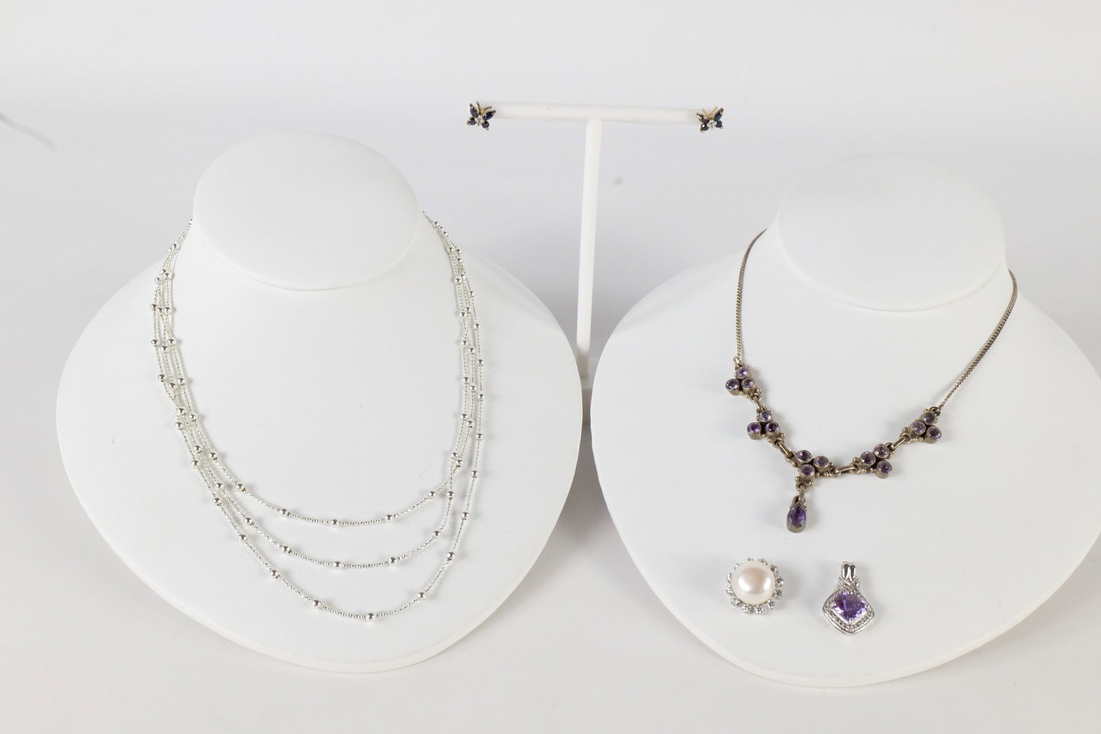 Lot of Sterling Jewelry: A lot of sterling silver jewelry including a three strand sterling and ball chain necklace, a vintage sterling and amethyst drop necklace, a pair of sterling and sapphire butterfly earrings, and a ste
