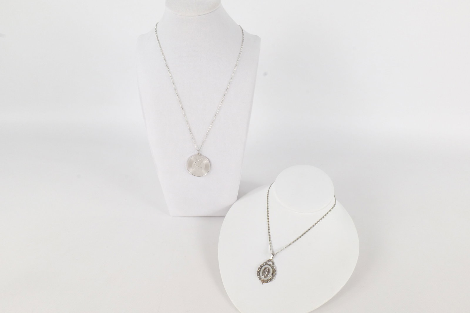 Lot of Sterling Jewelry: Lot of sterling jewelry including a heavy Franklin Mint UN peace medallion and a religious icon. Measures between 17" - 24". All invoices must be paid within 24 hours of the sale. We offer multiple sh