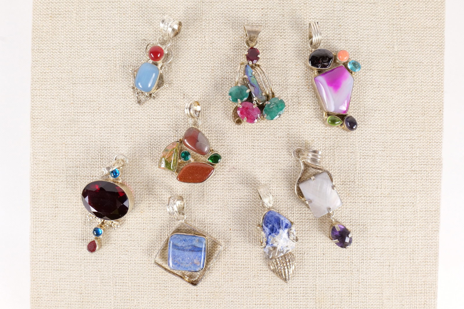 Lot of 8 Sterling Silver and Gemstone Pendants: Lot of 8 Sterling Silver and Gemstone Pendants. Set with Mother of Pearl, Peridot, Topaz, Amethyst, and More. Largest measures 2.5". All invoices must be paid within 24 hours of the sale. We offer mul