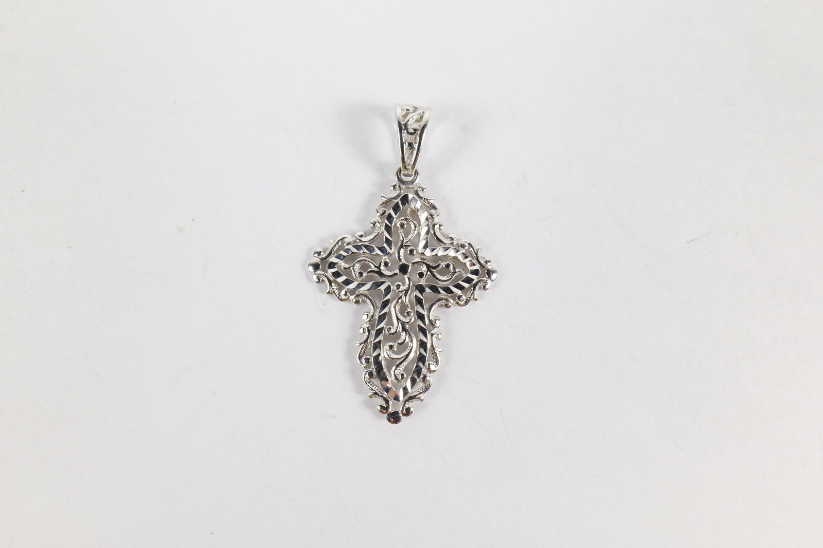 10k White Gold Diamond Cut Cross: 10k White Gold Diamond Cut Cross. Marked inside loop. Measures 1.5" wide. Weighs 2.7 grams. All invoices must be paid within 24 hours of the sale. We offer multiple shipping options, please read the