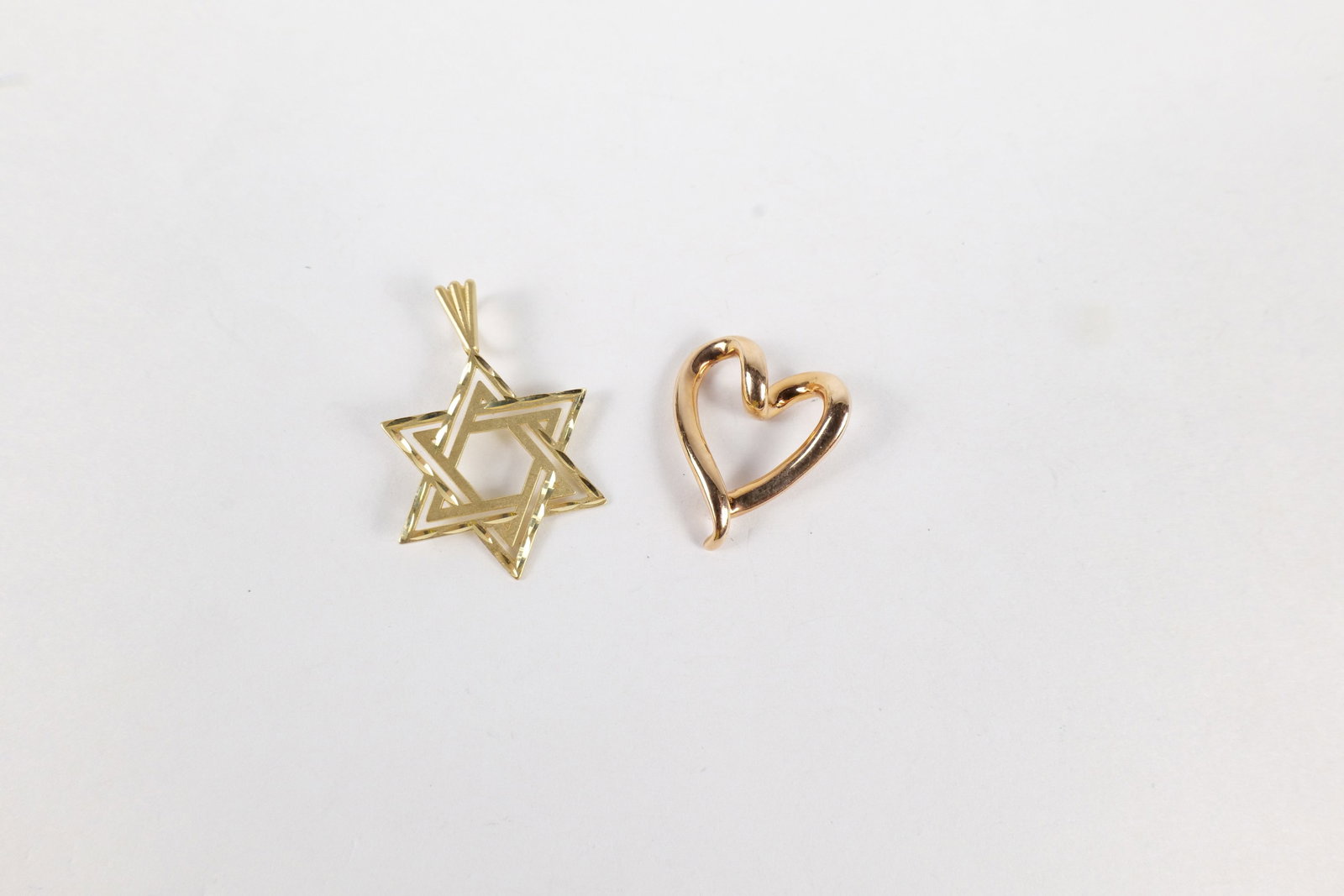 Lot of 2 14k Gold Charms: Lot of 2 14k Gold Charms. Including Rose Gold Heart Pendant and Yellow Gold Star of David. Bath marked. Largest measures 1". Weighs 2.5 grams. All invoices must be paid within 24 hours of the sale.
