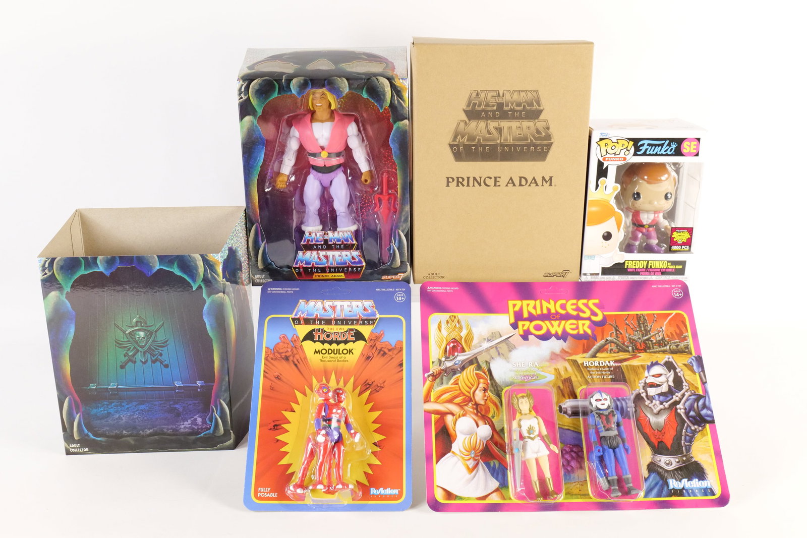 Group Lot of Masters of the Universe Toys: Group Lot of Masters of the Universe Toys. Including Super7 Prince Adam with Shipper, Super7 Princess of Power - She-Ra & Hordak, and Evil Horde - Modulok, and Funko - Freddy Funko as Prince Adam - Bl