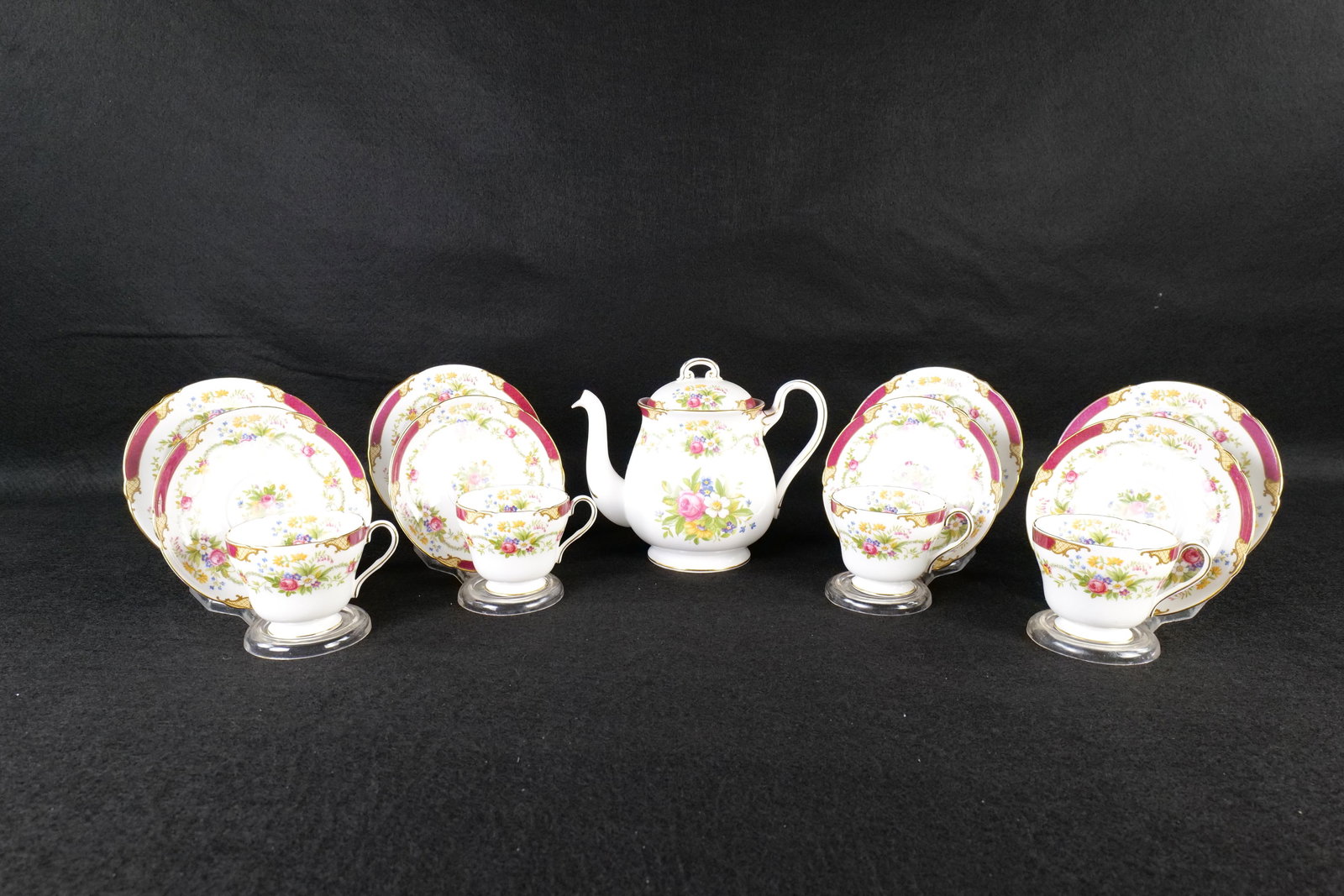 Group Lot of Shelley "Dubarry" Bone China: Group Lot of Shelley "Dubarry" Bone China. Including Teapot measuring 7" and 4 Trio Sets - Underplate, Saucer and Teacup - The book states Henley Shaped. Maroon Border. Pattern #13395. Circa 1940's-60