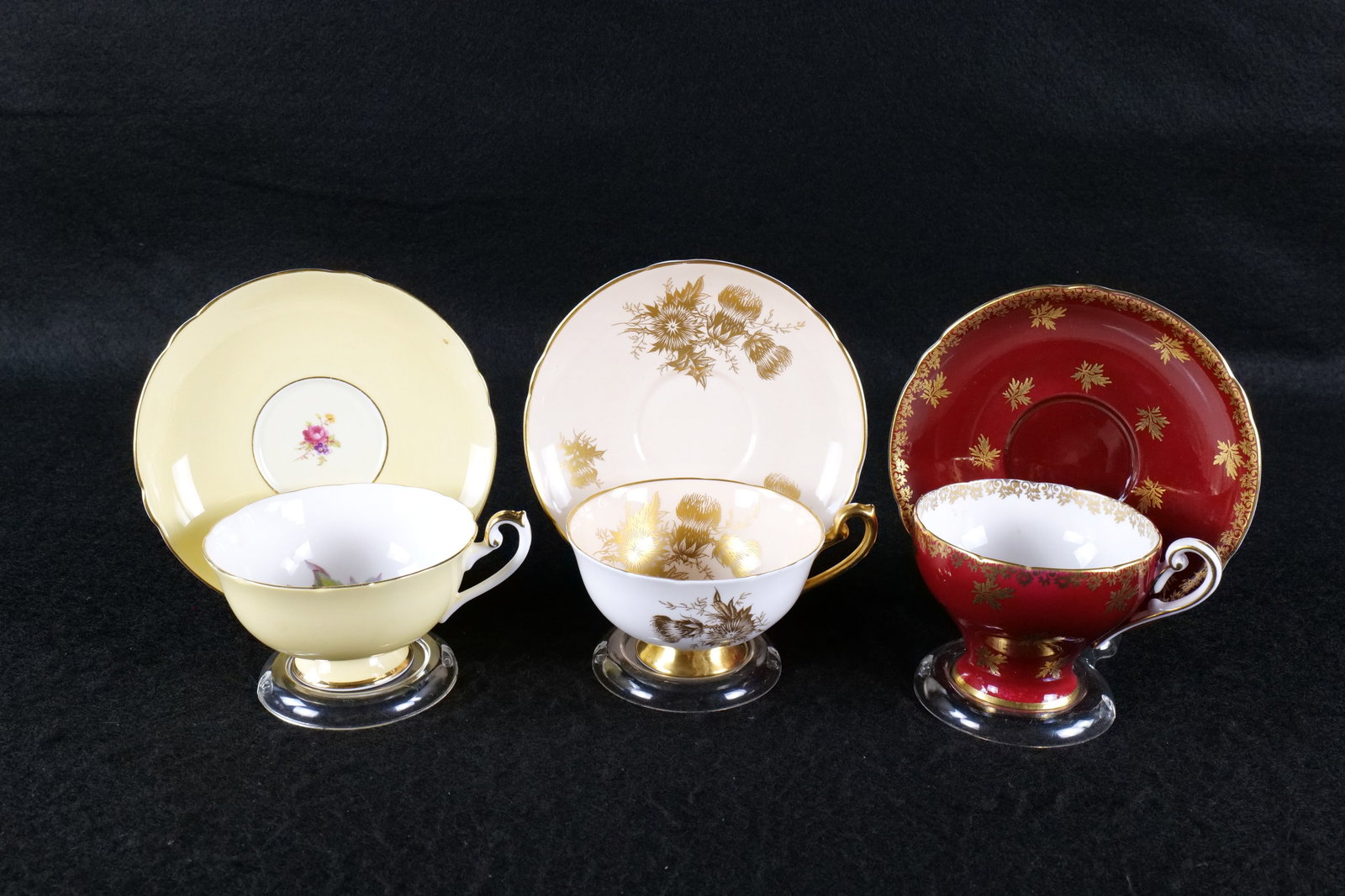 Lot of 3 Shelley Bone China Teacups and Saucers: Lot of 3 Shelley Bone China Teacups and Saucers. Including New Victoria Gold Leaves #0610 in Maroon, Lincoln Gold Thistle #0367 in Peach, and Lincoln Fruit Center on Yellow #14208. This Shelley Collec