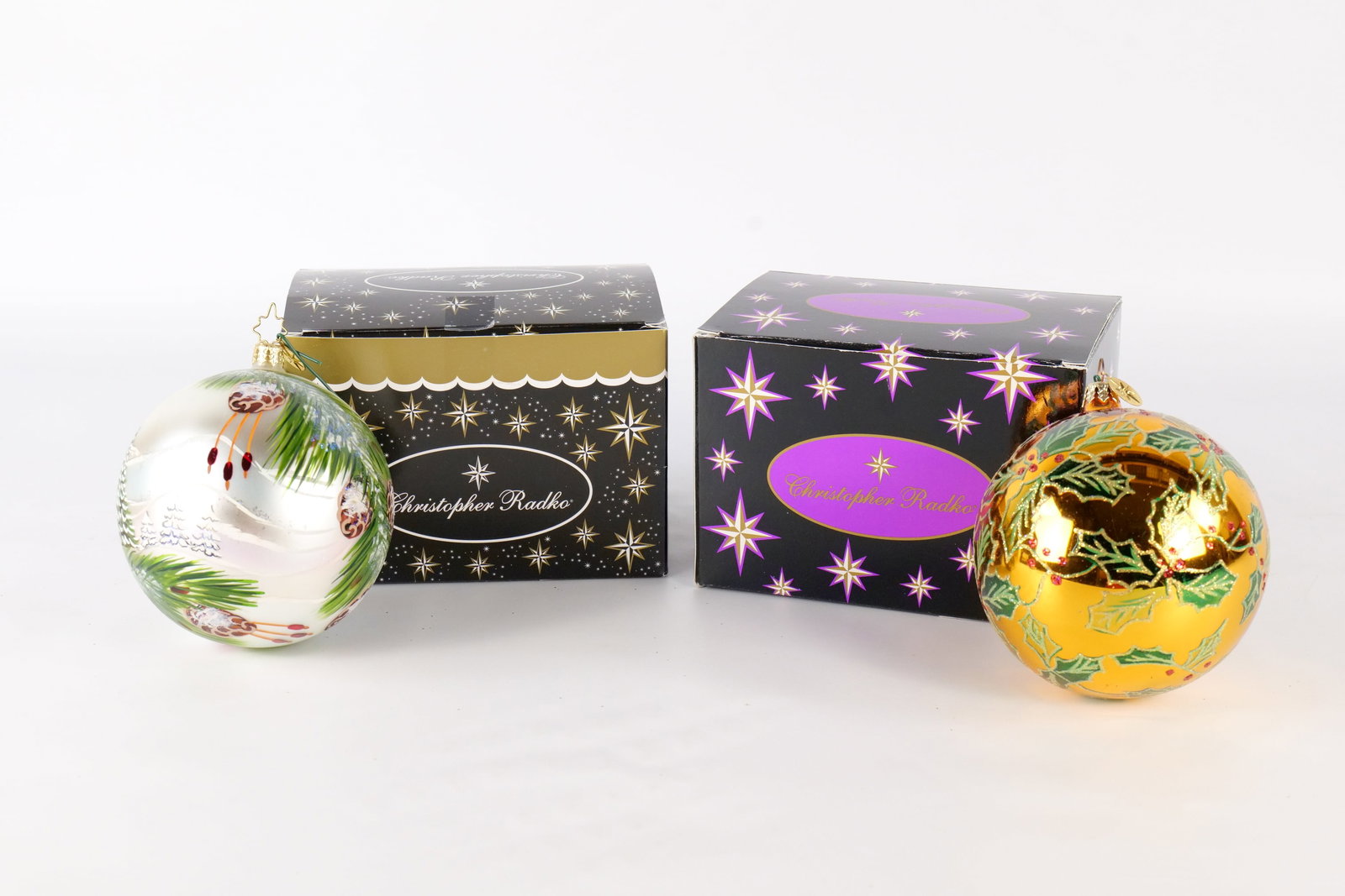 Lot of 2 Christopher Radko Ball Ornaments: Lot of 2 Christopher Radko Ball Ornaments. Including Pine Horizons and Holly Grove. Measures approx. 5". Both come with Radko boxes that may not be original. All invoices must be paid within 24 hours 