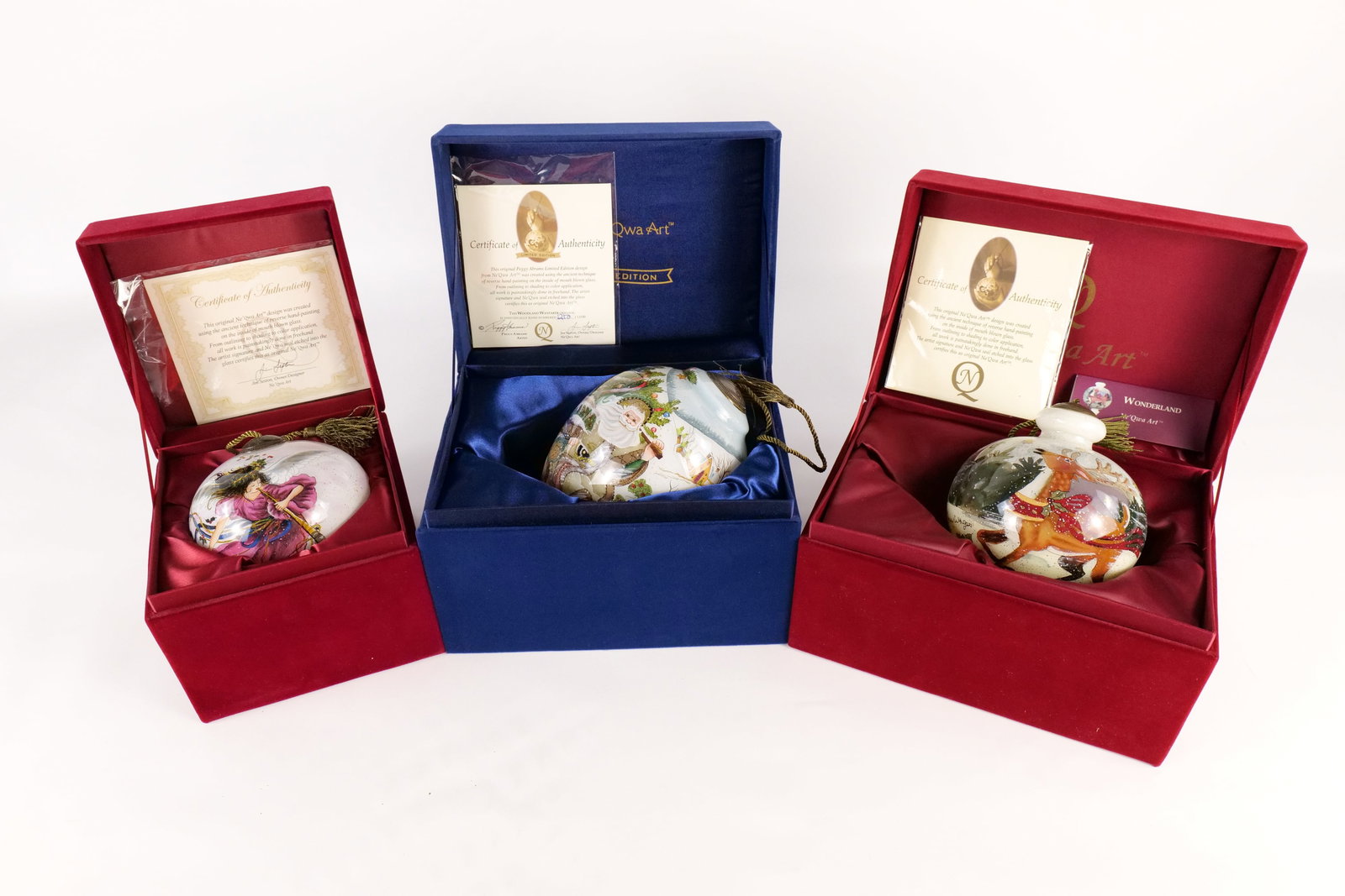 Lot of 3 Ne Qwa Art Ornaments: Lot of 3 Ne Qwa Art Ornaments. Reverse Hand Painted Blown Glass. Including Woodland Wayfarer Original Limited Edition, Reindeer, and Angel with Holly Leaves. All come with boxes and COA's. All invoice