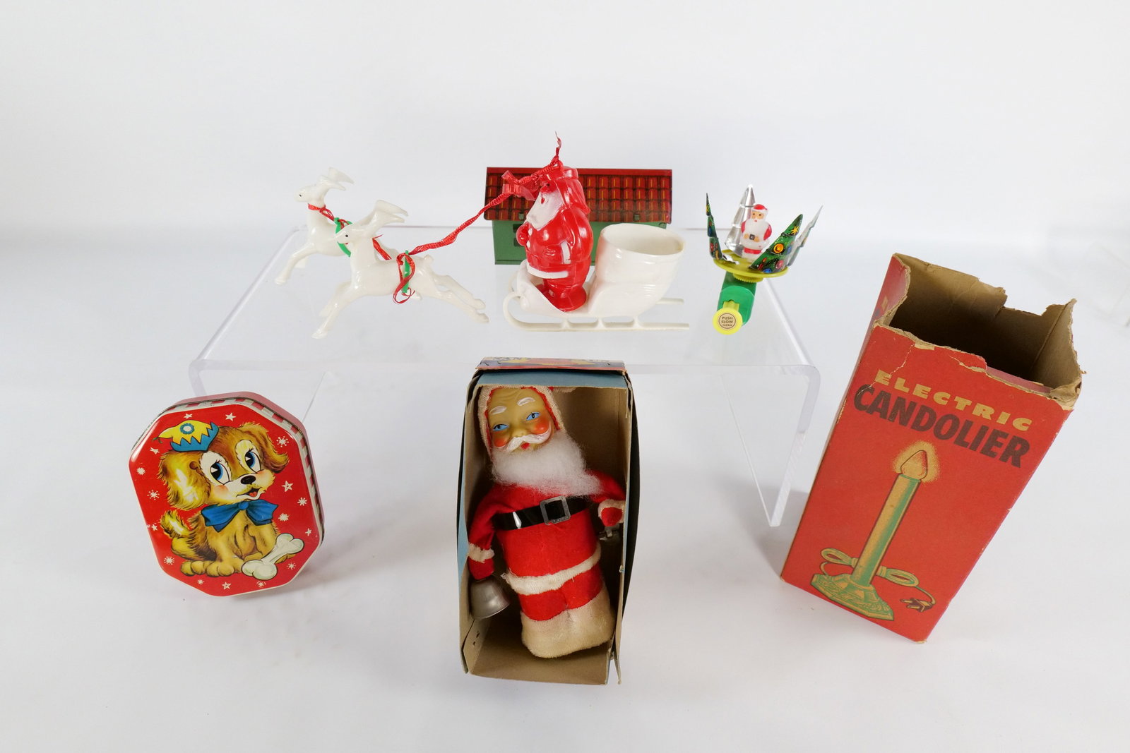 Lot of Mostly Christmas Items: Lot of Mostly Christmas Items. Including Mechanical Wind Up Santa in Original Box measuring 6.75" tall - Box has tears, Plastic Santa and Sled - Missing something in hands, Vintage Metal Tin with Bulb