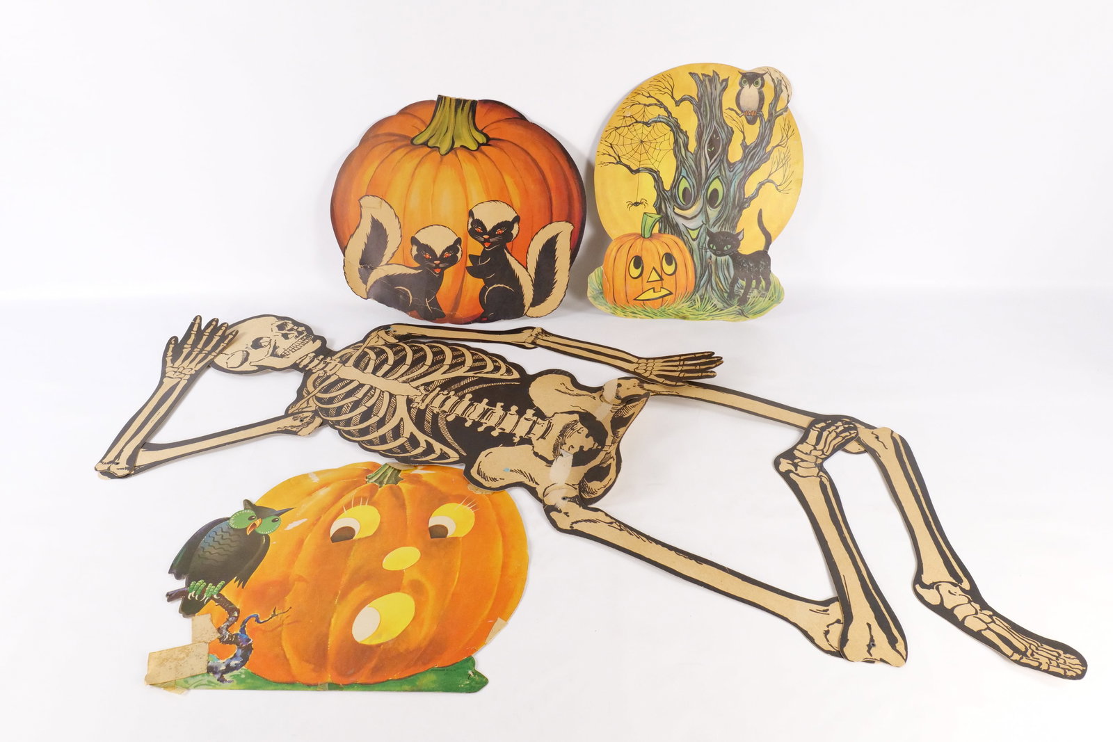 Lot of Halloween Cardboard Cutouts: Lot of Halloween Cardboard Cutouts. Including Haunted Tree, Pumpkin with Skunks, Giant Jointed Skeleton, and More. They have some tears, staining, pinholes, tape, etc. Largest measures 54.5" long. All