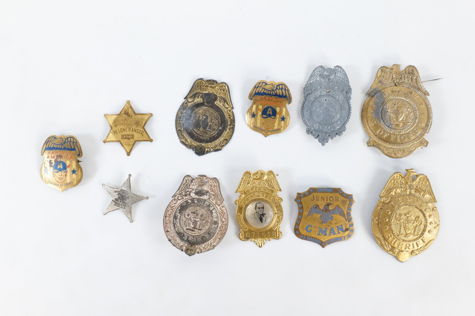 Lot of Toy Metal Badges: Lot of Toy Metal Badges. Including Junior G Man Liquid Vita Malt, Captain America, Deputy Sheriff, The Lone Ranger, Special Counter Spy Jr. Agent and More. Two are missing pinbacks. All invoices must 