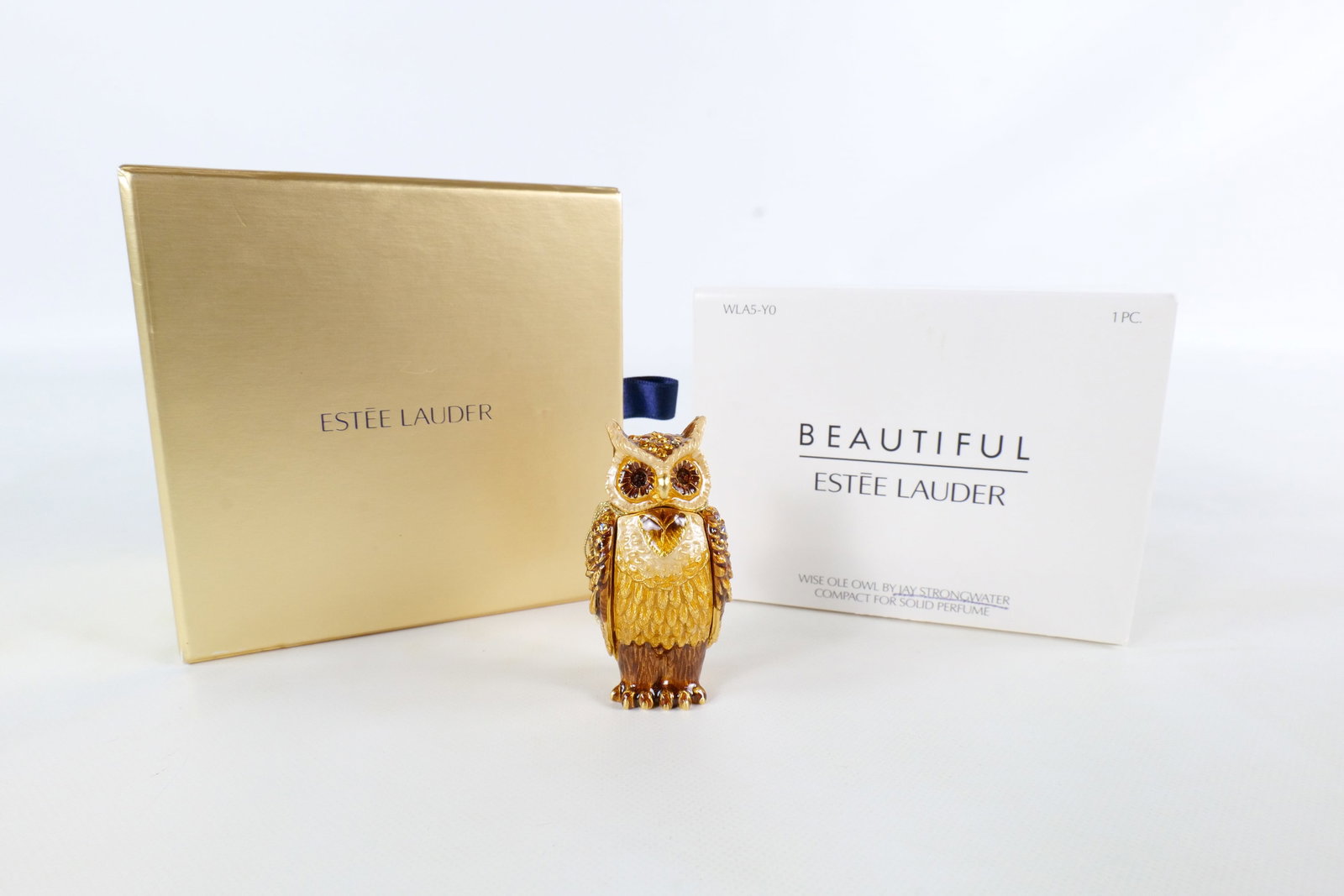 Estee Lauder/Jay Strongwater Wise Ole Owl Perfume Compact: 2010 Estee Lauder Wise Ole Owl Compact for solid perfume. Designed by Jay Strongwater. Unused. Amber and cream enamel owl with corresponding rhinestones/crystals throughout. Comes with the original bo