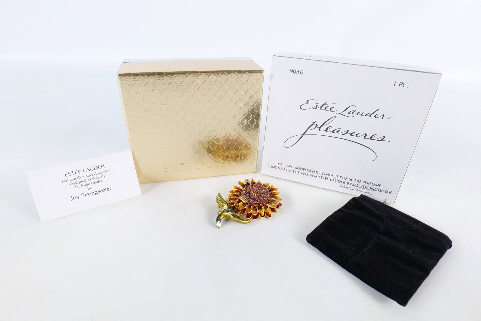 Estee Lauder/Jay Strongwater Radiant Sunflower Perfume Compact: 2003 Estee Lauder Radiant Sunflower compact for solid perfume - Pleasures. Designed by Jay Strongwater. Unused. A red and yellow enamel sunflower with purple, amber and pink rhinestones/crystals in th