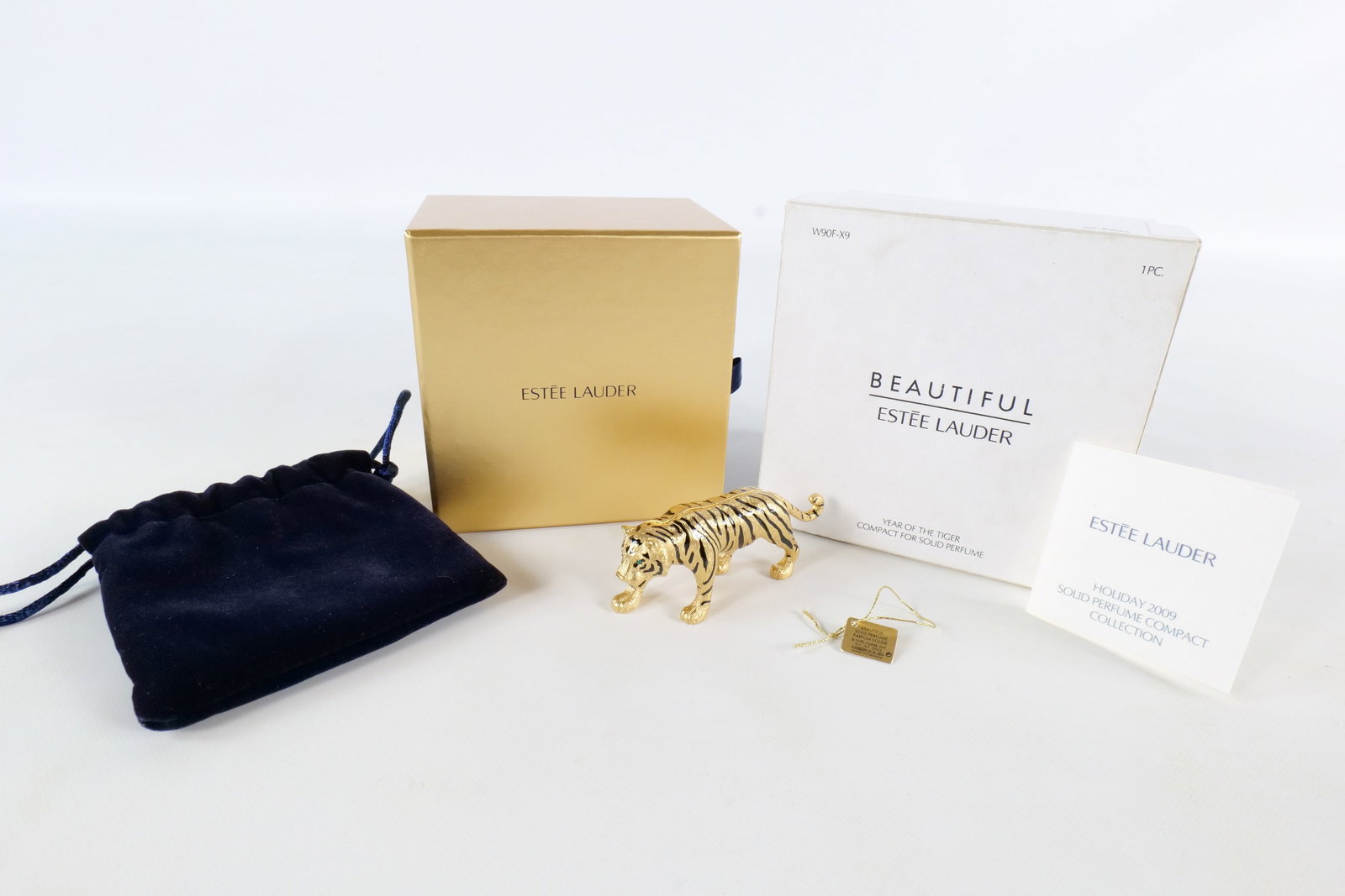 Estee Lauder Year of the Tiger Perfume Compact: 2009 Estee Lauder Year of the Tiger compact for solid perfume - Beautiful. Unused Gold tone tiger with black enamel stripes and rhinestone/crystal eyes. Comes with original box, outer box, paperwork, 