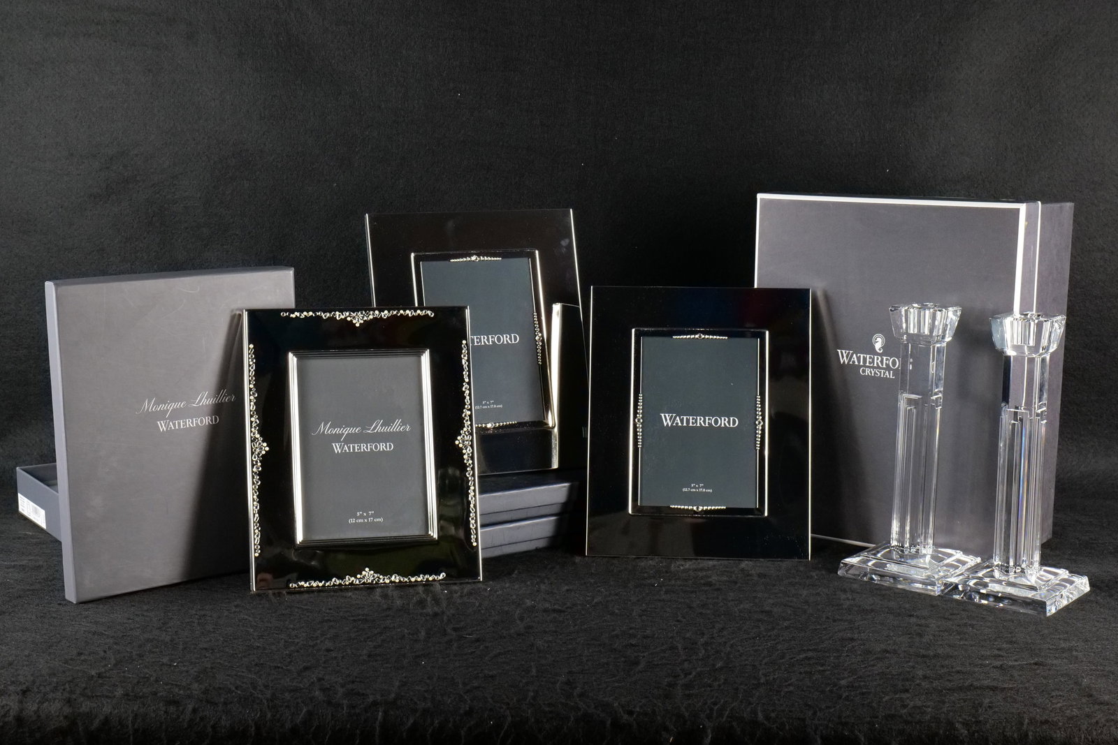 Group of Waterford Crystal: Group of Waterford crystal including a pair of column art deco style candlesticks with original box, and 3 Waterford silver plate and jeweled 5 x 7 picture frames. Candlesticks measure approx.. 10" ta