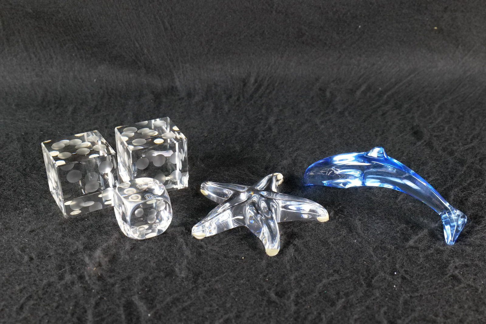 Group of Art Glass Items: Group of art glass items. Mostly as is, including Baccarat blue dolphin with chip on fin, Baccarat starfish with large chip on underside, 1 Baccarat die in good condition and a pair of crystal dice si