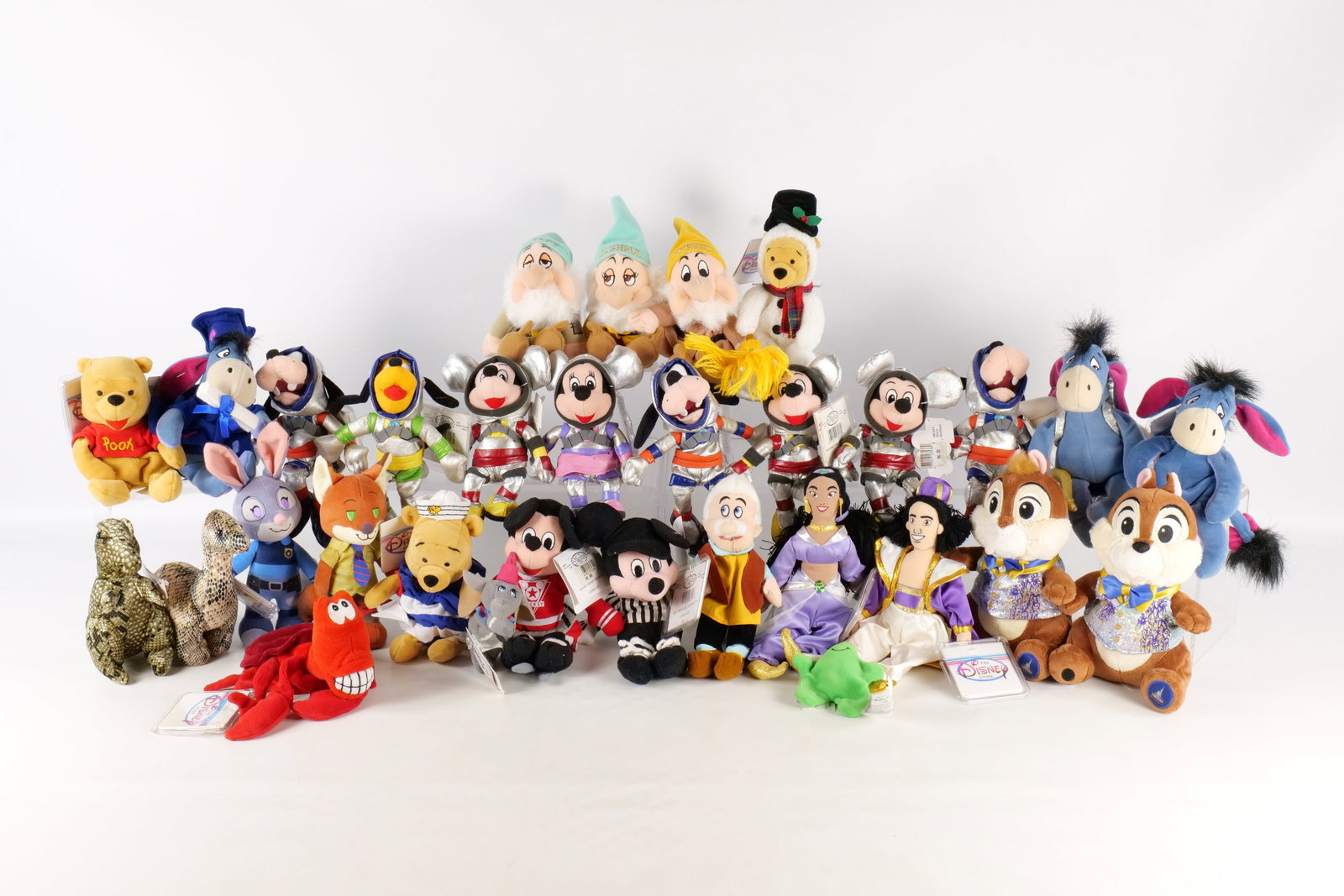 Lot of Disney Bean Bag Plush: Lot of Disney Bean Bag Plush. Including Jasmine, Aladdin, Chip, Dale, Goofy in Spacesuit, Mickey in Spacesuit, Graduation Eeyore, Some Dwarfs, and More. Many have tags attached. All invoices must be p