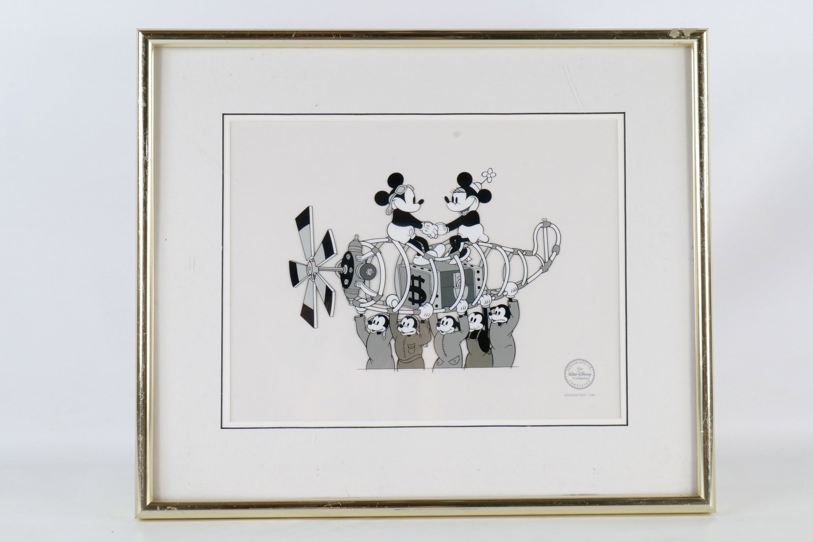 Walt Disney "The Mail Pilot" Limited Edition Serigraph Cel: Walt Disney "The Mail Pilot" Limited Edition Serigraph Cel. Depicting Minnie and Mickey Mouse. Dated 1990. Edition of 2500 pieces. Framed and matted. The gold frame has some scuffing and wear. Measure