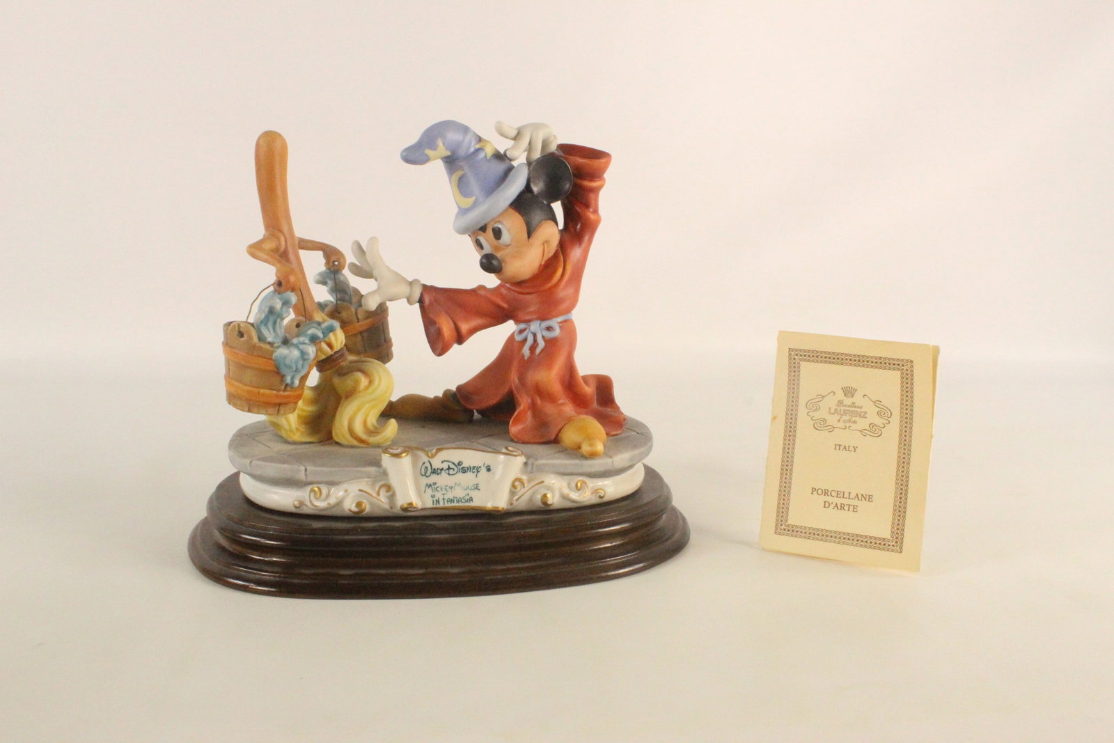 Laurenz Capodimonte Mickey Mouse in Fantasia Figurine: Laurenz Capodimonte Mickey Mouse in Fantasia Figurine. Mounted on wooden base. Made in Italy. Comes with certificate. Measures 9 1/2 inches tall by 11 inches wide. All invoices must be paid within 24 