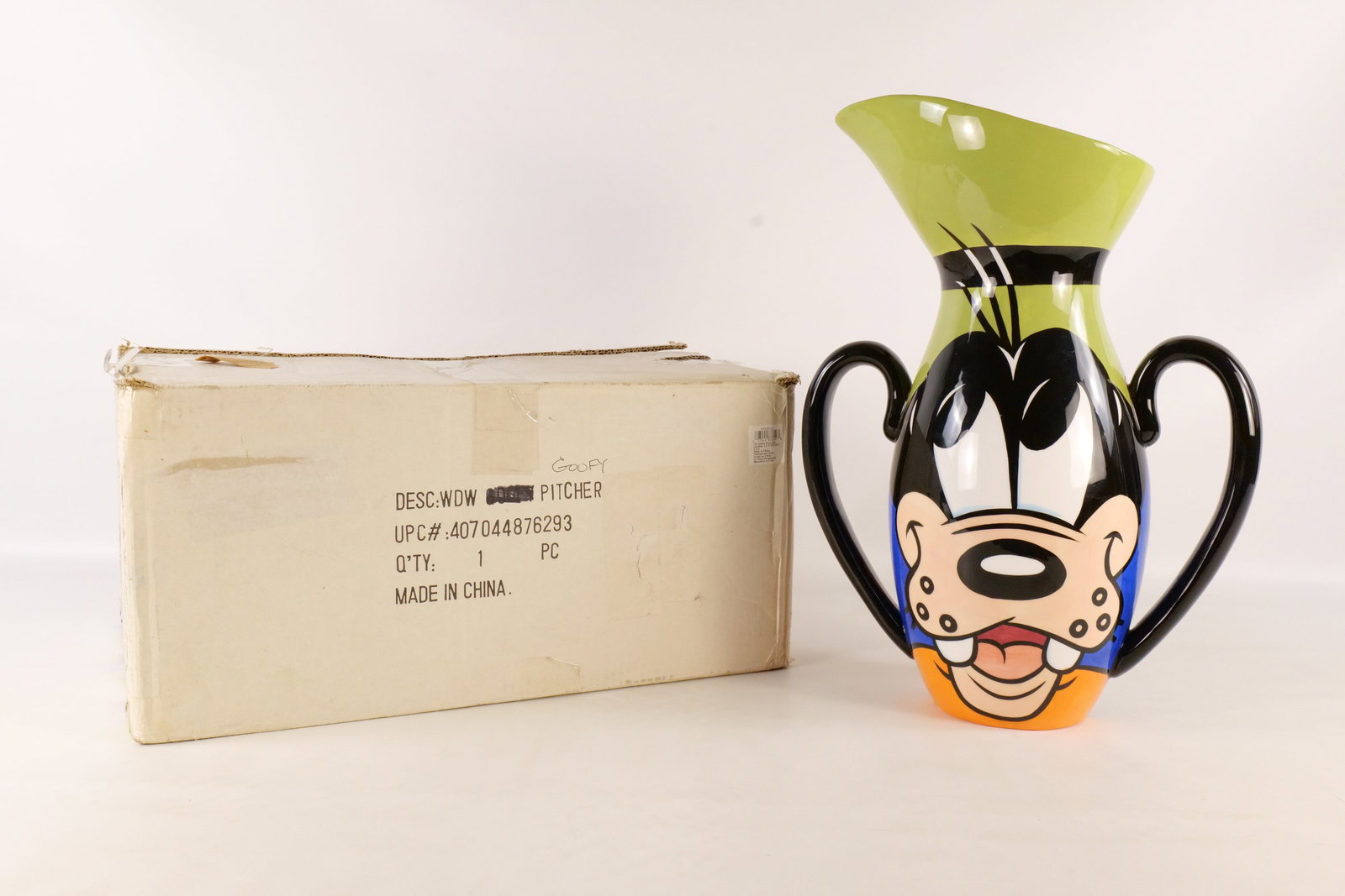 Disney Auctions Maleficent Limited Edition Ceramic Vase: The Art of Disney Goofy Double Handled Ceramic Pitcher. Has some crazing to the glaze and an imperfection or small repair. Measures 8 1/4 inches tall by 13 1/2 inches wide. Comes without outer shipper