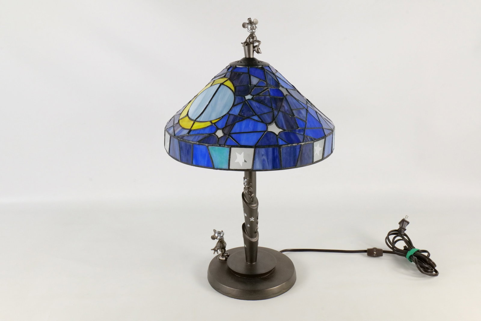 Mickey Mouse 75th Anniversary Stained Glass Lamp: Mickey Mouse 75th Anniversary Stained Glass Lamp. Depicting Mickey on the base and Minnie as the finial. When it lights up there will be a shadow image of Mickey and Minnie kissing. Very rare. Measure