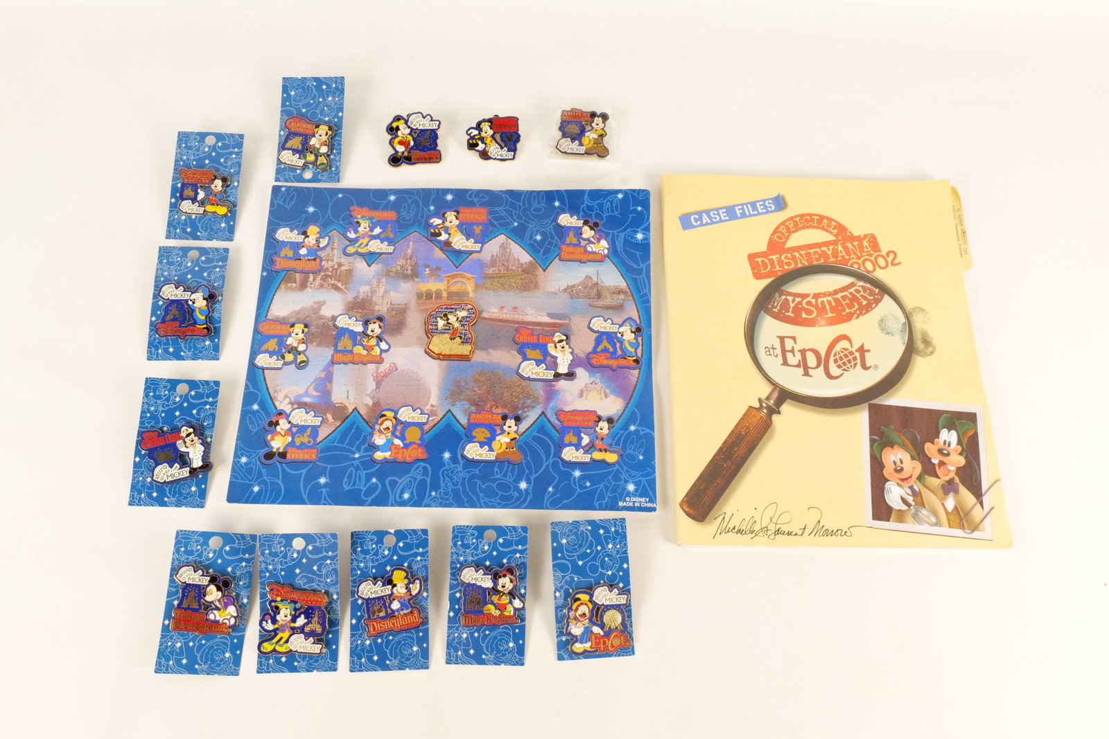 Lot of Disney Collectibles: Lot of Disney Collectibles. Including the Disneyana 2002 Manual with 24 Disney Artist Autographs and 2005 Limited Edition - Around the World with Mickey Pin Set with cardboard backing. The pin set is 
