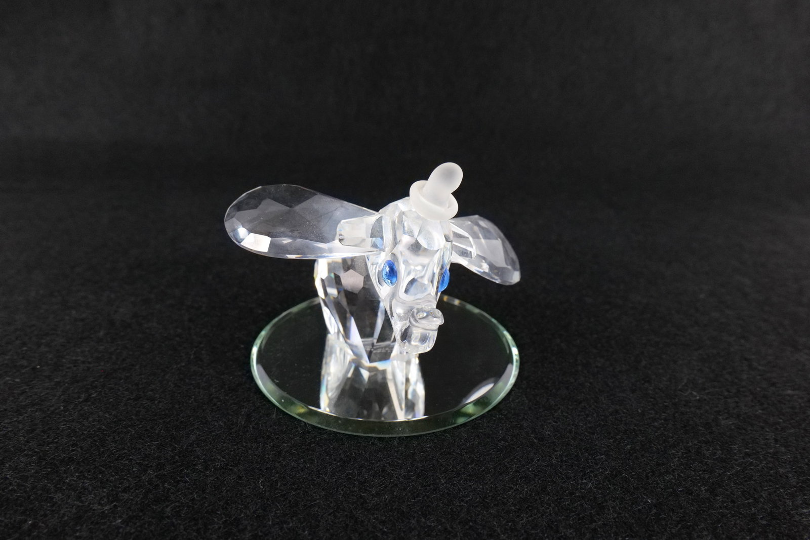 Disney Swarovski Crystal Dumbo with Blue Eyes Figurine: Disney Swarovski Crystal Dumbo with Blue Eyes Figurine. Artist signed. Comes with mirror base. Measures 2 inches tall. All invoices must be paid within 24 hours of the sale. We offer multiple shipping