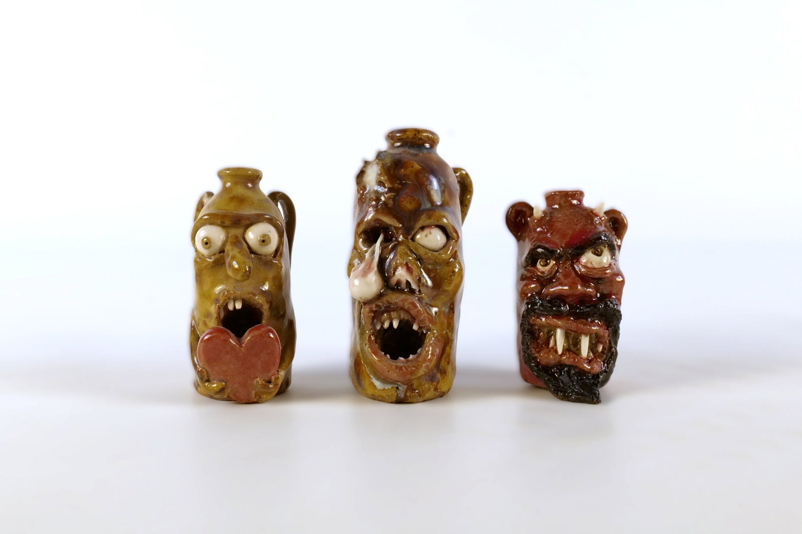 Lot of 3 Ed Berdej Miniature Studio Art Pottery Ceramic Face Jugs/Bottles: Lot of 3 Ed Berdej Miniature Studio Art Pottery Ceramic Face Jugs/Bottles - Monster, Zombie and Devil. The zombie features a dramatic melting/dripping glaze, open snarling mouth with teeth, and a sign