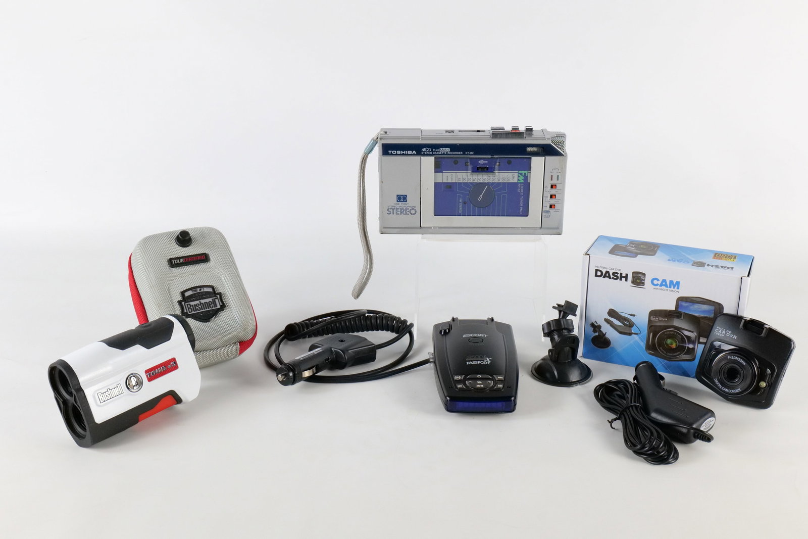 Assorted electronics Lot: Assorted electronics including a Toshiba KT-R2 recorder, Bushnell rangefinder, Escort radar detector, and a dash camera. All invoices must be paid within 24 hours of the sale. We offer multiple shippi