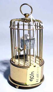 SMALL BRASS FIGURAL CLOCK: SMALL BRASS FIGURAL CLOCK, in the form of a bird in a bird cage, the bird points to the central globe to indicate the time; 5 inch height