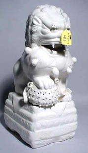 LARGE GLAZED BLANC DE CHINE FIGURE OF A MALE FOO L: LARGE GLAZED BLANC DE CHINE FIGURE OF A MALE FOO LION, depicted with it's front paw on an orb representing the word, with stepped rectangular base; 14 inch height