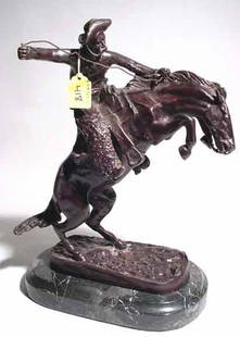 AFTER FREDERIC REMINGTON: AFTER FREDERIC REMINGTON; patinated bronze group on marble base; ''The Bronco Buster''; 14 inch height