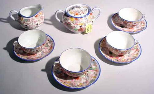 TEN PIECE FLORAL DECORATED TEA SET: TEN PIECE FLORAL DECORATED TEA SET, the decorations depicting figures in a landscape, includes four cups and saucers, covered creamer and sugar