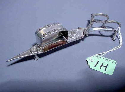 ENGLISH SILVERPLATED CANDLE SNUFFER, having a hi: ENGLISH SILVERPLATED CANDLE SNUFFER, having a hinged scissor design with shell and foliate chasing; 6-3/4 inch length NOTE: Sold for the benefit of the Museum of Fine Arts, Houston