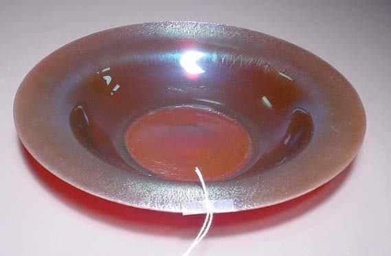 IRIDESCENT ART GLASS SHALLOW BOWL WITH WIDE LIP, o: IRIDESCENT ART GLASS SHALLOW BOWL WITH WIDE LIP, of a purplish/blue coloration, with polished pontil, unsigned; 12-1/2 inch diameter; 2-3/8 inch height (tiny flake chip to edge of rim)