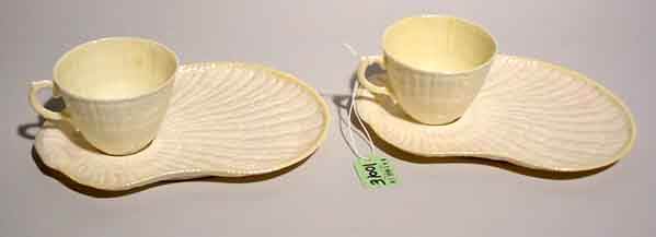 PAIR OF IRISH BELLEEK T.V. SETS, of shell form,: PAIR OF IRISH BELLEEK T.V. SETS, of shell form, with cob luster glaze finish, one cup bearing the 6th green mark, the other cup and both saucers bearing the 5th green mark; 8-1/4 inch length (one cup