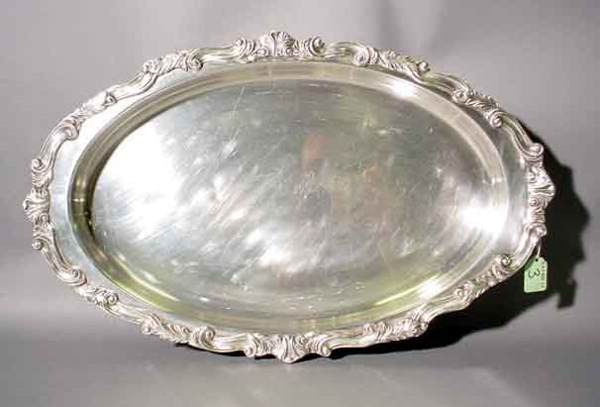 LARGE SILVERPLATED OVAL SERVING DISH, having a folia: LARGE SILVERPLATED OVAL SERVING DISH, having a foliate scroll edge and feet, with a Pyrex liner; 20-1/2 inch length (Est. 40-60)