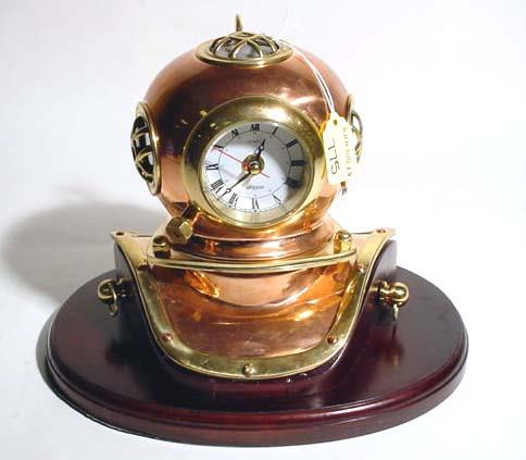 DECORATIVE POLISHED BRASS AND COPPER MANTLE CLOCK: DECORATIVE POLISHED BRASS AND COPPER MANTLE CLOCK, modeled as an old diving helmet, on a mahogany oval base; 8-1/4 inch height
