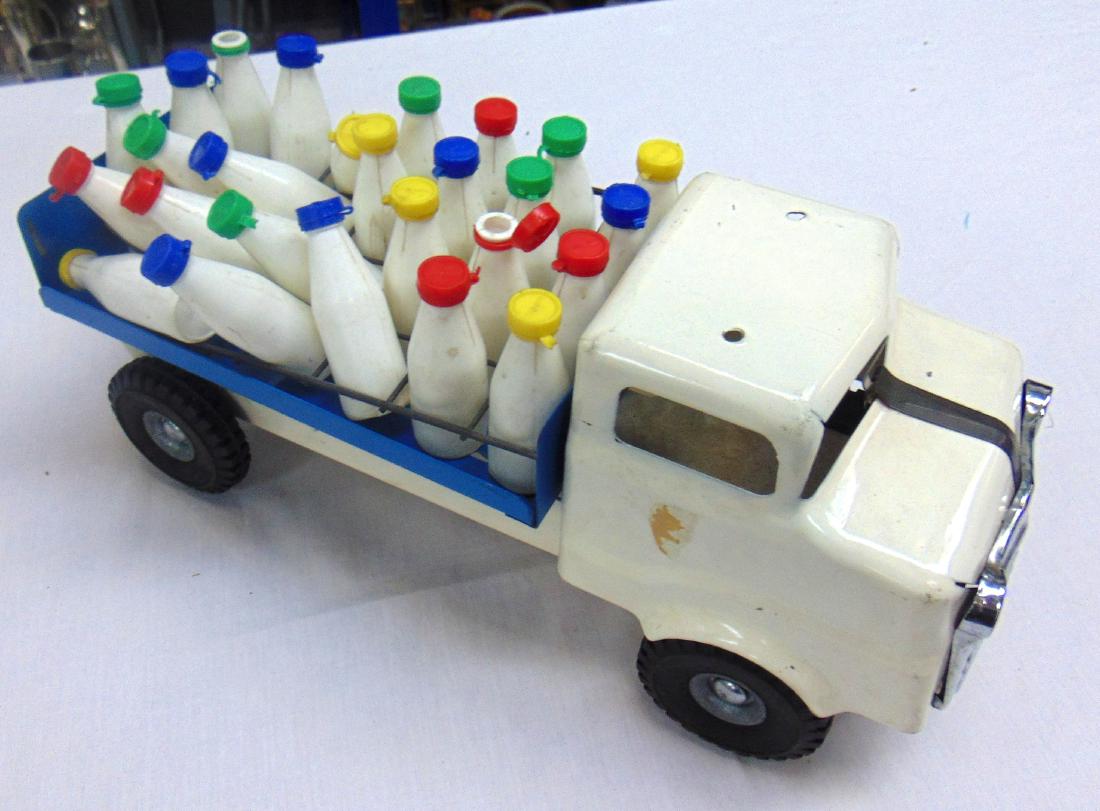 A VINTAGE JAPANESE TOY COW, with large rubber udders,: A VINTAGE JAPANESE TOY COW, with large rubber udders, together with a toy milk float. (2)