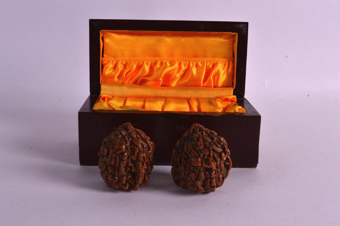 A PAIR OF EARLY 20TH CENTURY CHINESE CARVED NUTS formed (1 of 2)