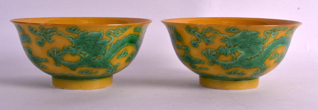 A PAIR OF CHINESE SANCAI TYPE YELLOW GROUND BOWLS: A PAIR OF CHINESE SANCAI TYPE YELLOW GROUND BOWLS bearing Kangxi marks to base, decorated with five claw dragons. 5.75ins diameter.