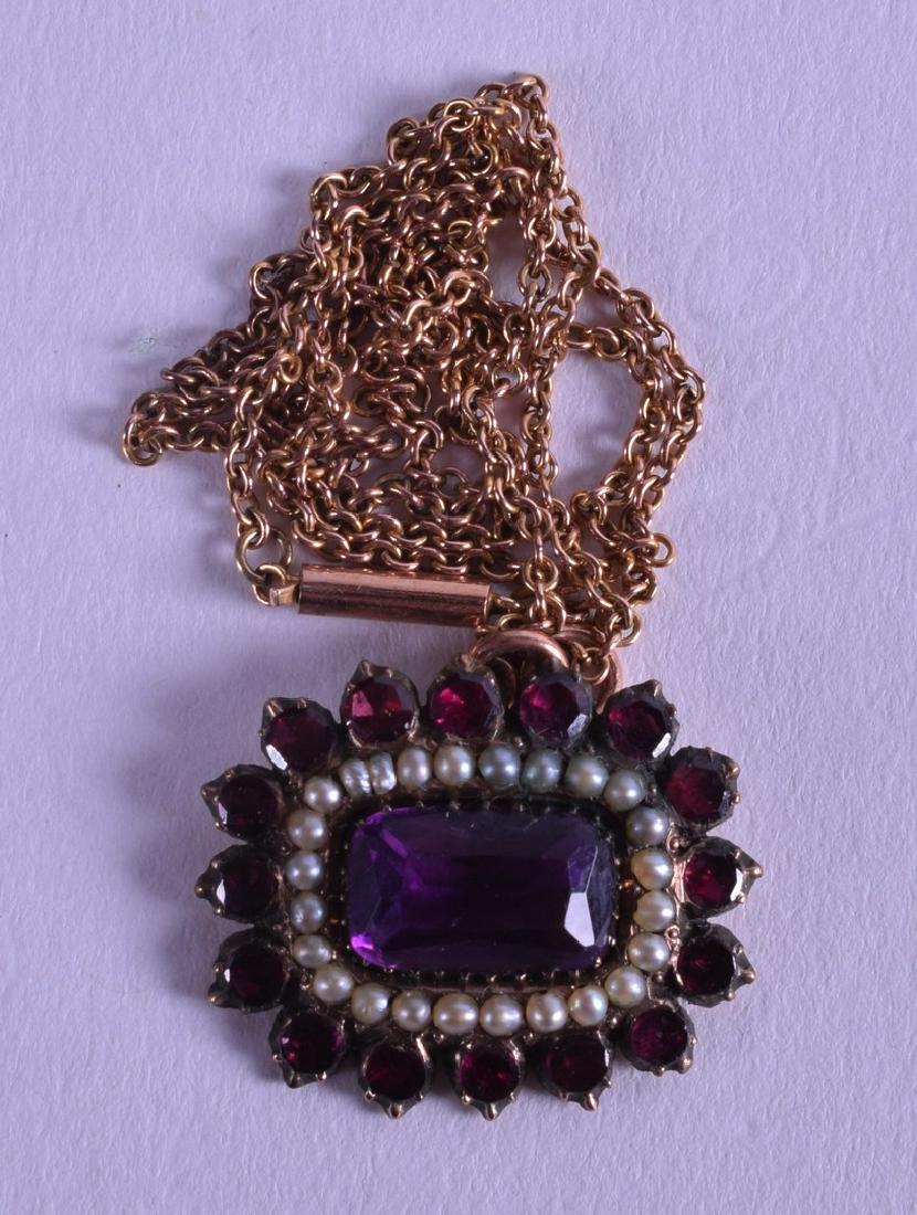 AN EDWARDIAN YELLOW GOLD AMETHYST AND GARNET PENDANT.: AN EDWARDIAN YELLOW GOLD AMETHYST AND GARNET PENDANT.