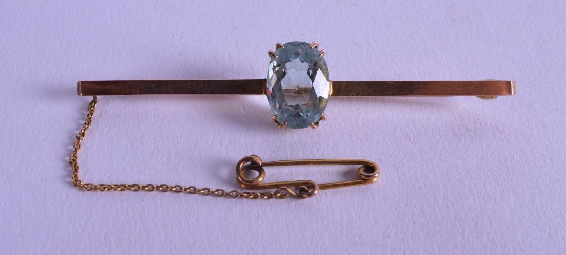 AN EDWARDIAN YELLOW GOLD AND AQUAMARINE BAR BROOCH.: AN EDWARDIAN YELLOW GOLD AND AQUAMARINE BAR BROOCH.