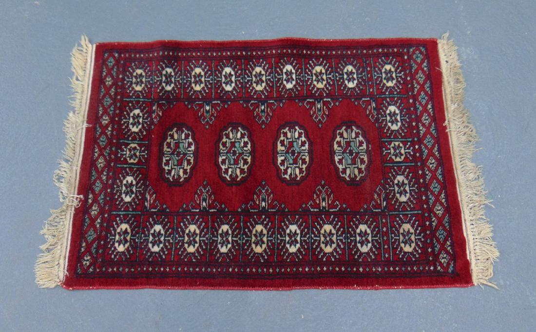 A SMALL RED GROUND PERSIAN RUG, decorated with MOTIFS (1 of 3)