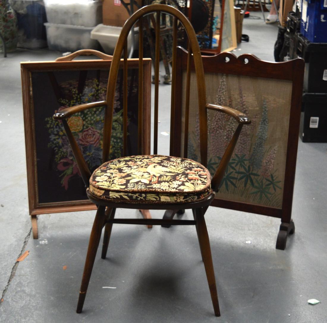 A VINTAGE ERCOL CHAIR together with two embroidered and: A VINTAGE ERCOL CHAIR together with two embroidered and glazed fire screens. (3)