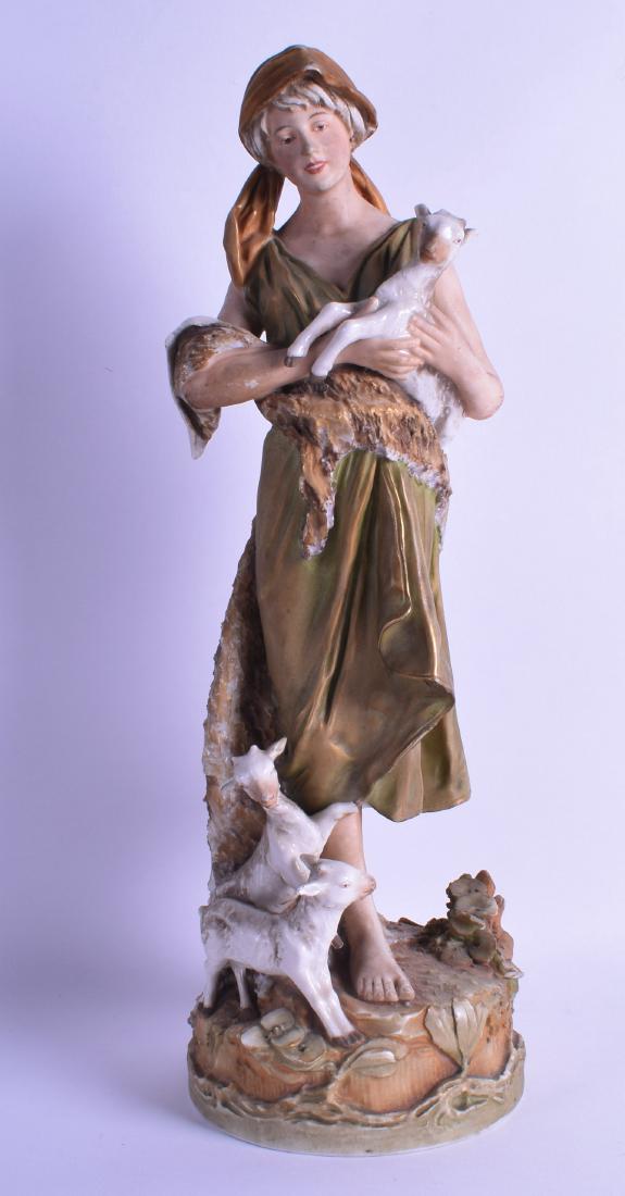 AN ART NOUVEAU ROYAL DUX FIGURE OF A STANDING FEMALE: AN ART NOUVEAU ROYAL DUX FIGURE OF A STANDING FEMALE modelled beside two goats. 44 cm high.