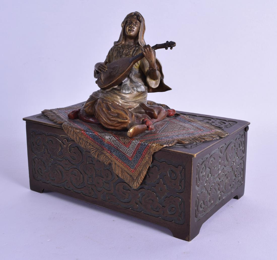 A RARE LATE 19TH CENTURY AUSTRIAN COLD BRONZE PAINTED: A RARE LATE 19TH CENTURY AUSTRIAN COLD BRONZE PAINTED MUSICAL CASKET AND COVER Attributed to Franz Xavier Bergmann, modelled as a female musician upon a rug. 16 cm wide.
