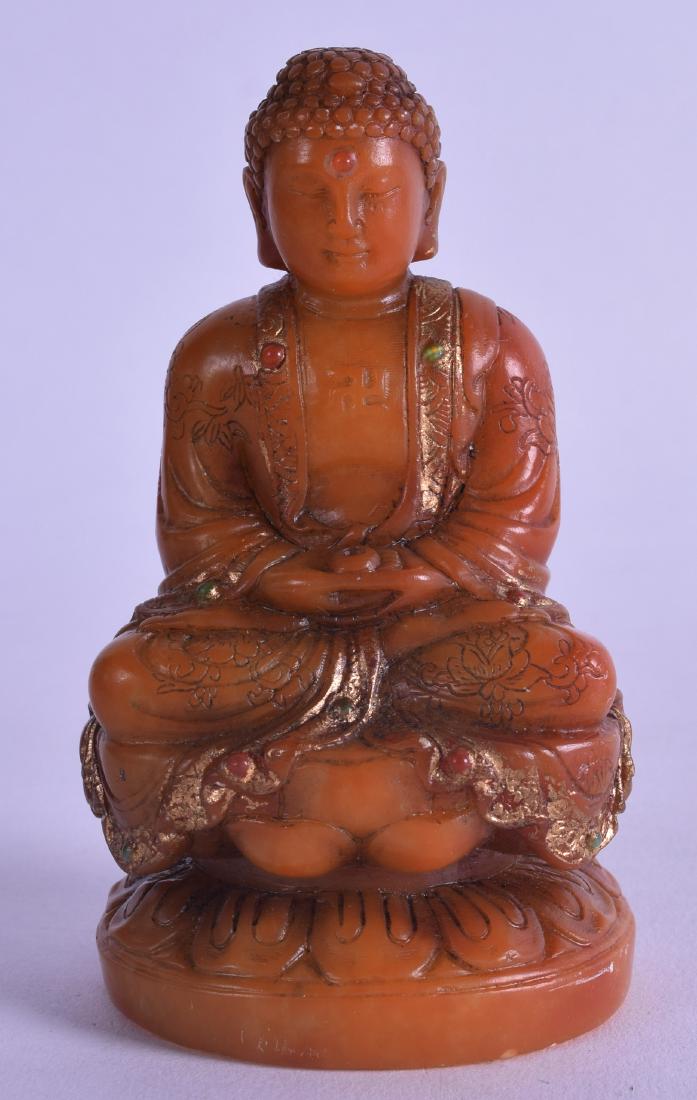 A CHINESE CARVED SOAPSTONE FIGURE OF A BUDDHISTIC GOD: A CHINESE CARVED SOAPSTONE FIGURE OF A BUDDHISTIC GOD modelled upon a lotus column. 9.25 cm high.